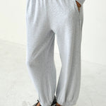 Person wearing gray sweatpants and polka dot shoes on a white background