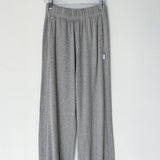Gray sweatpants hanging on a wooden hanger against a white background
