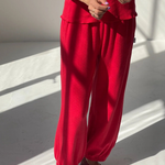 Person wearing a red outfit with matching shoes on a light background