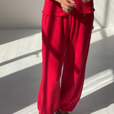 Person wearing a red outfit with matching shoes on a light background