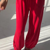 Person wearing a red outfit with matching shoes on a light background