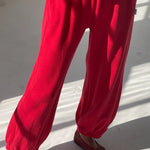 Red pants worn by a person on a white floor