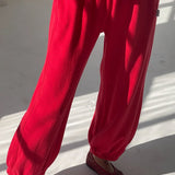 Red pants worn by a person on a white floor