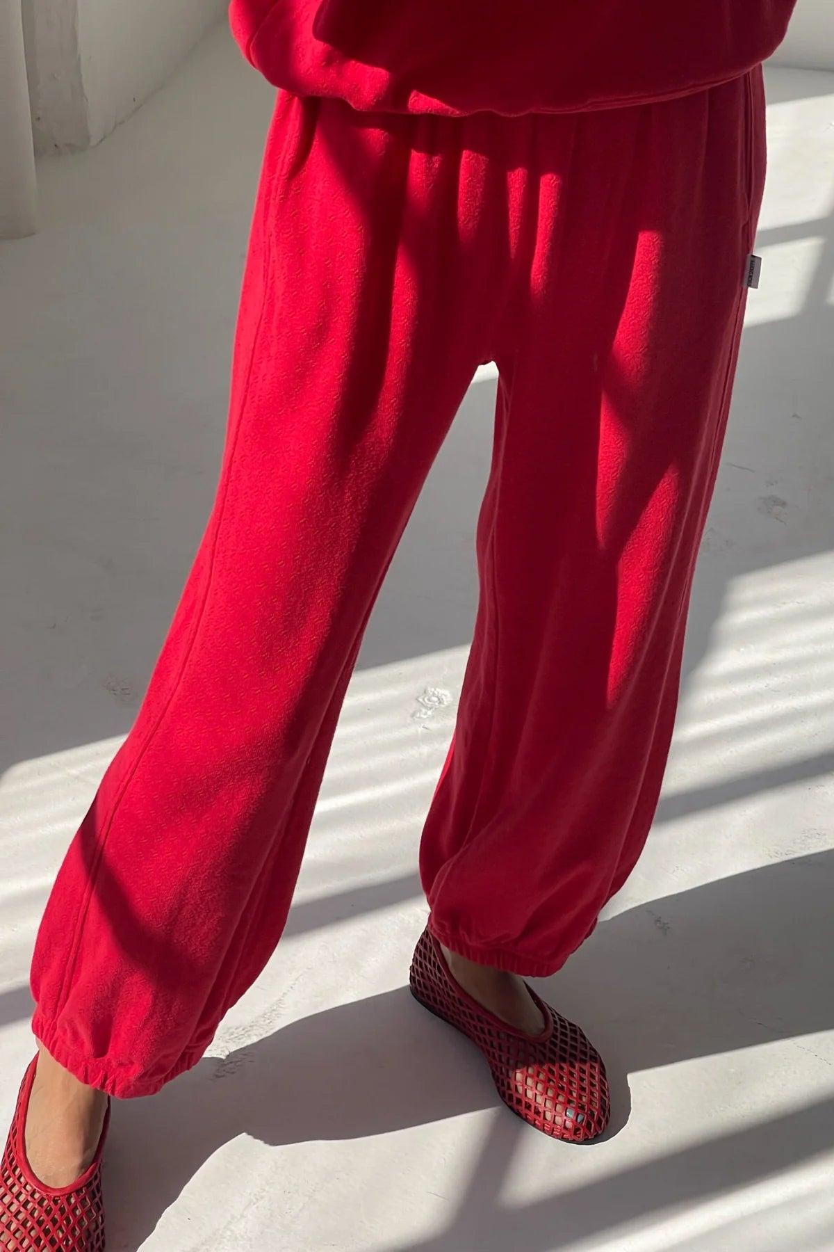 Red pants worn by a person on a white floor