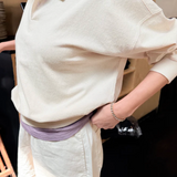 Person wearing a light-colored outfit with a collar, standing indoors.