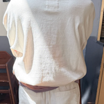 Beige short-sleeve shirt and pants on a mannequin against a neutral background