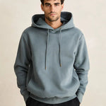 Man wearing a light blue hoodie against a beige background