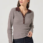 Woman wearing a striped shirt with a brown collar on a plain background