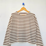 Striped long-sleeve shirt on a hanger against a white background