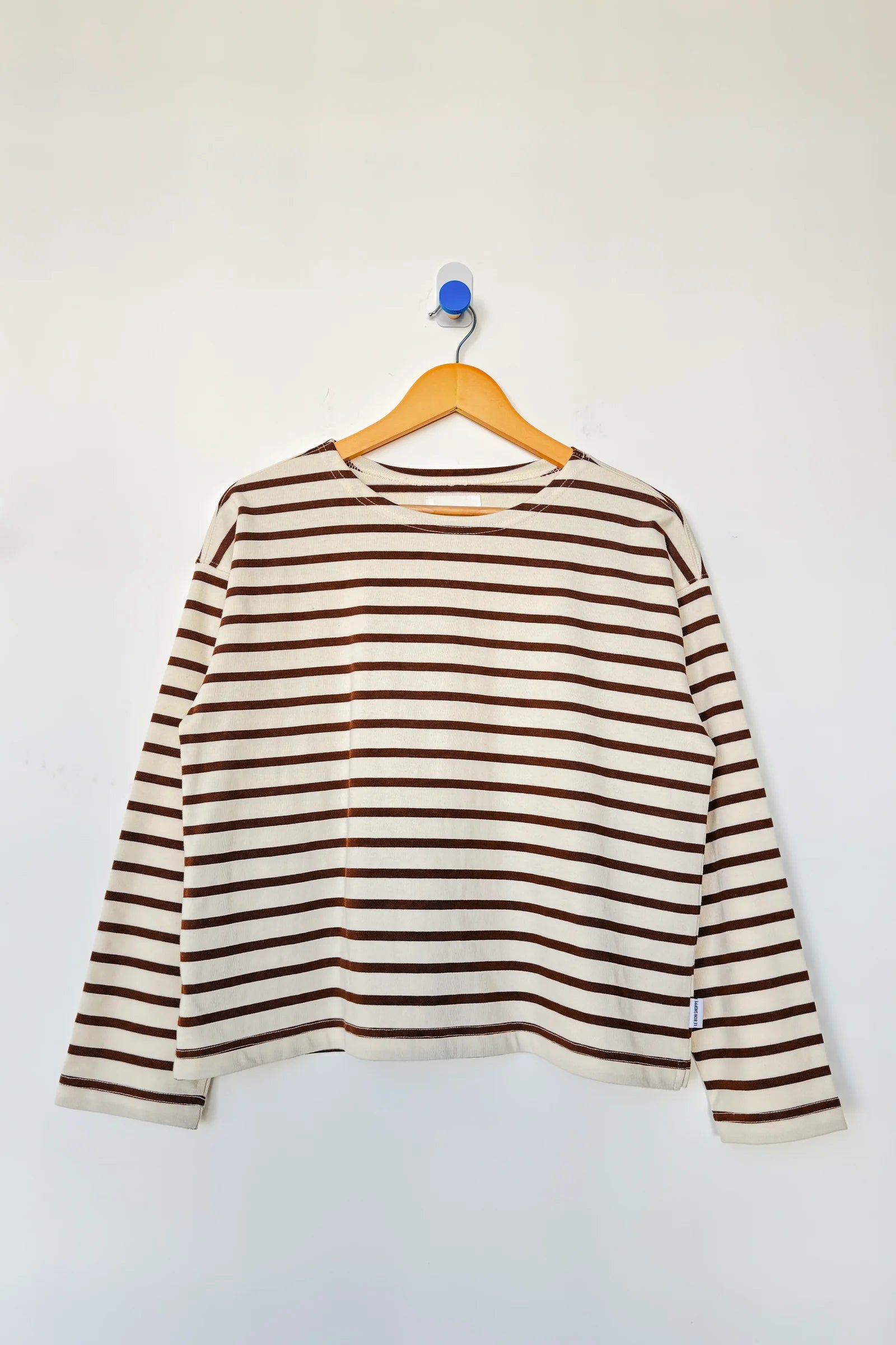 Striped long-sleeve shirt on a hanger against a white background