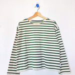 Green and white striped shirt on a hanger against a white background
