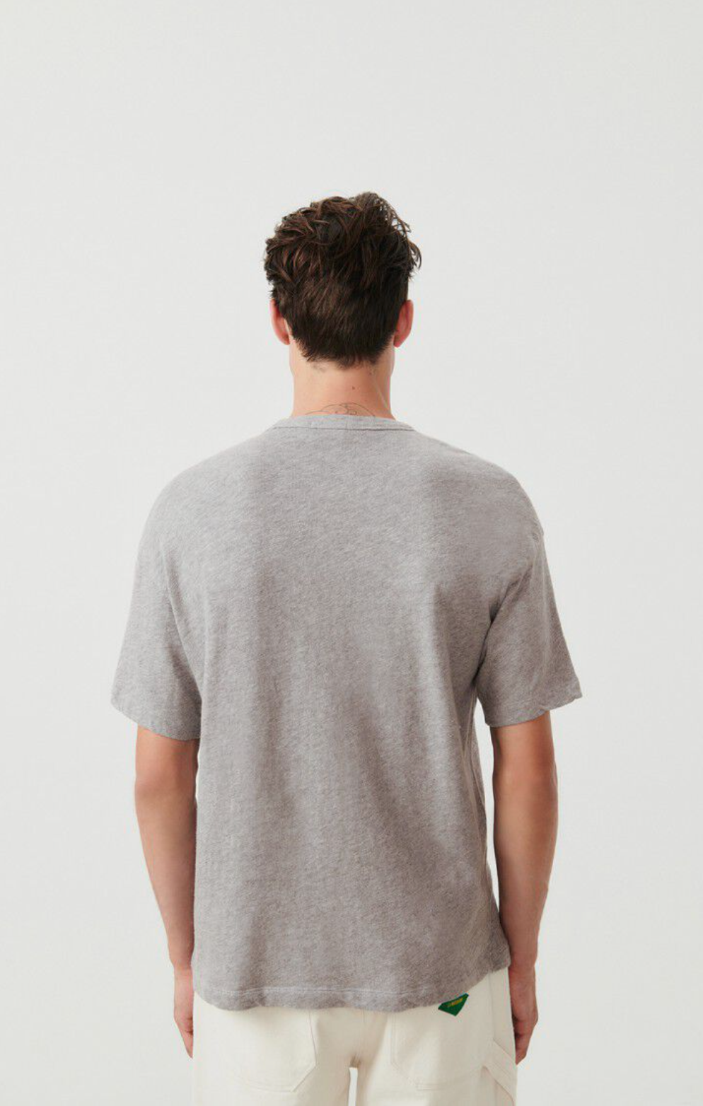 A medium close up image of the back side of a male model wearing the Sonoma T-shirt in grey