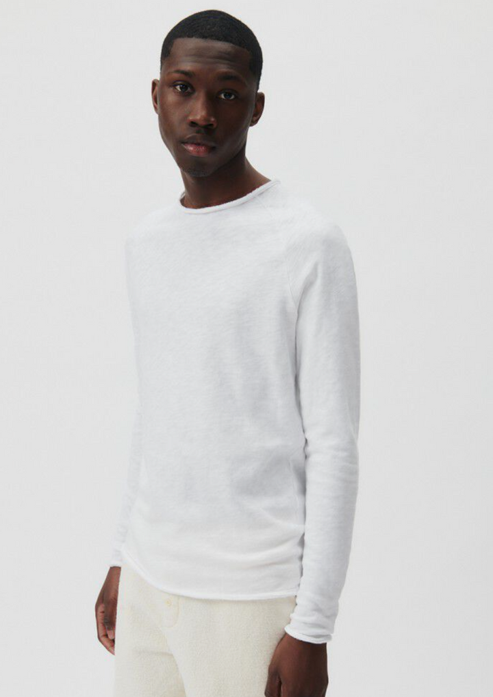 A medium close image showing a male model standing at an angle wearing the Sonoma Long Sleeve in white