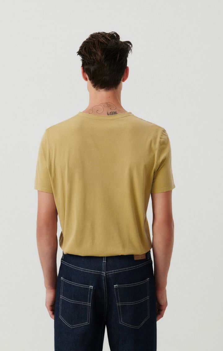 medium close image of  the backside of a male model wearing the devon t-shirt in vintage safari color tucked into dark denim