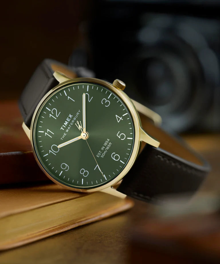 Timex watch with green dial and brown leather strap on a wooden surface