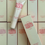 Suavina lip balm packaging with a tube and boxes on a matching background