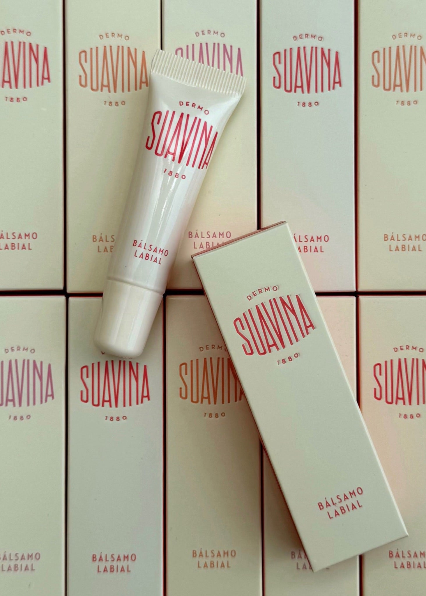Suavina lip balm packaging with a tube and boxes on a matching background