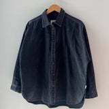 Dark denim shirt on a hanger against a white background