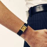 Breda Virgil Lizard watch with black embossed leather strap and gold dial on wrist