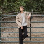 Person standing in a fenced area with trees in the background