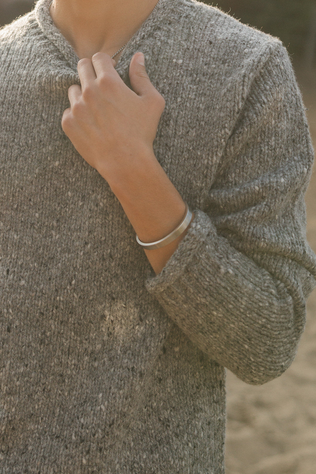Person wearing a textured sweater with a blurred background