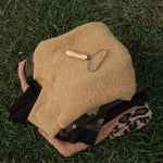 Beige helmet with a tool on grass