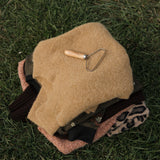 Beige helmet with a tool on grass