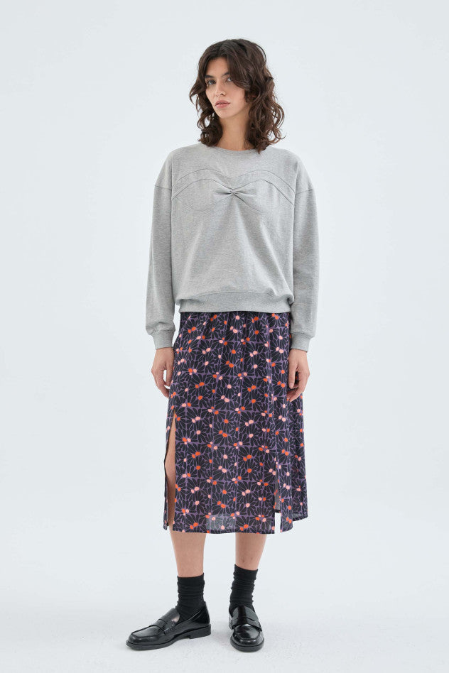 A full body image of a female model wearing the Sweatshirt With Seam Detail styled with a floral midi skirt and black loafers