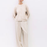 Person wearing a beige outfit on a white background