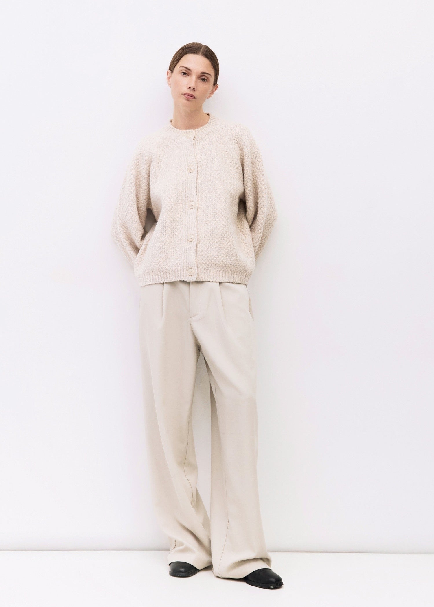 Person wearing a beige outfit on a white background