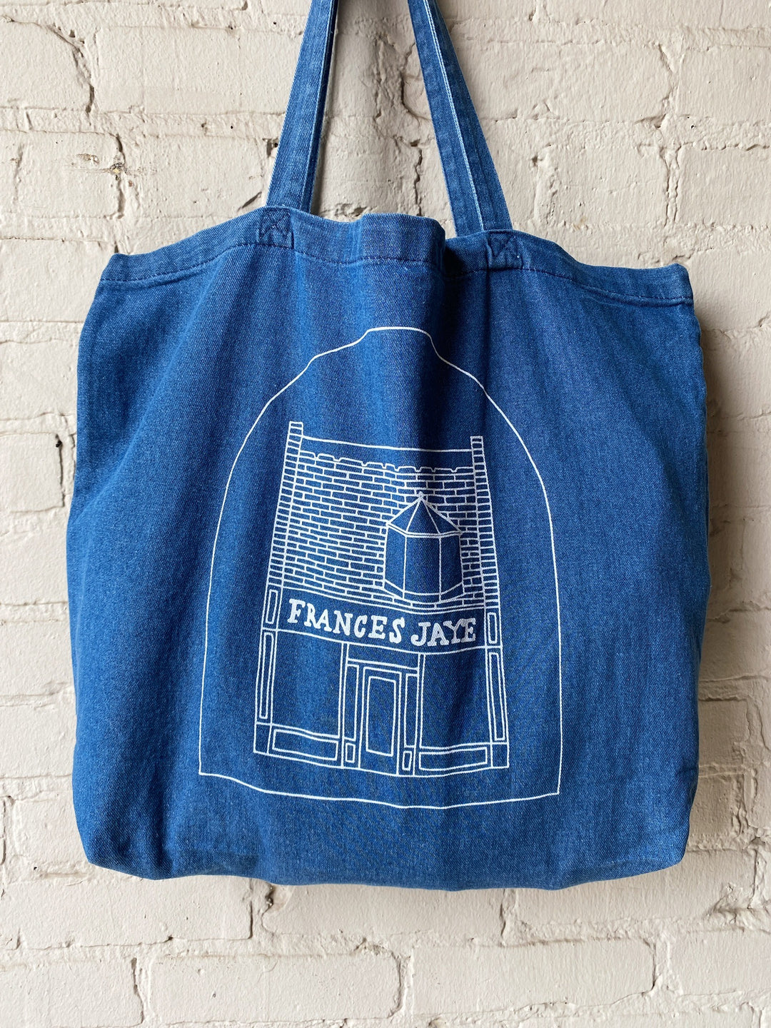 A denim tote with a sketch of the Frances Jaye store front on it.