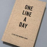 One Line a Day journal laying on grey background.