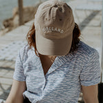 Female model wearing shorts, a short sleeve shirt and tan hat embroidered with Holland