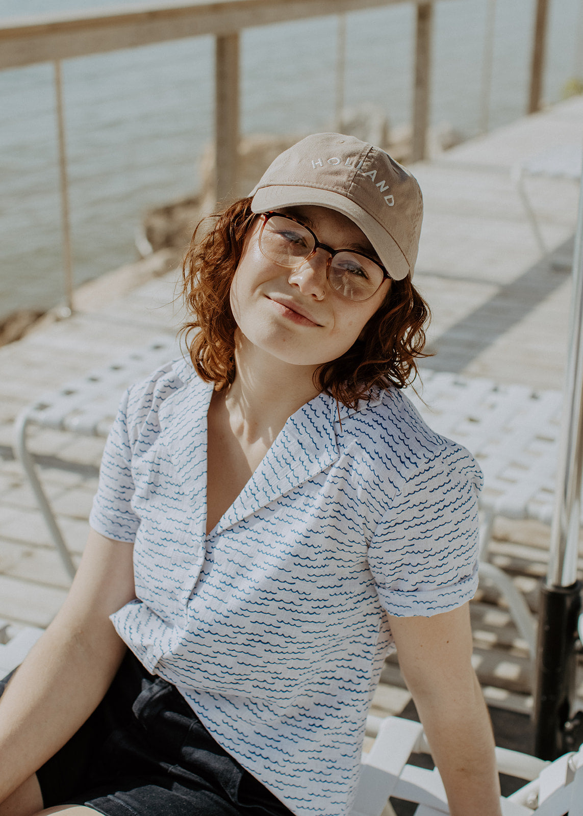 Female model wearing shorts, a short sleeve shirt and tan hat embroidered with Holland