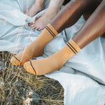A pair of socks worn by a person sitting, with the socks' color and pattern visible.