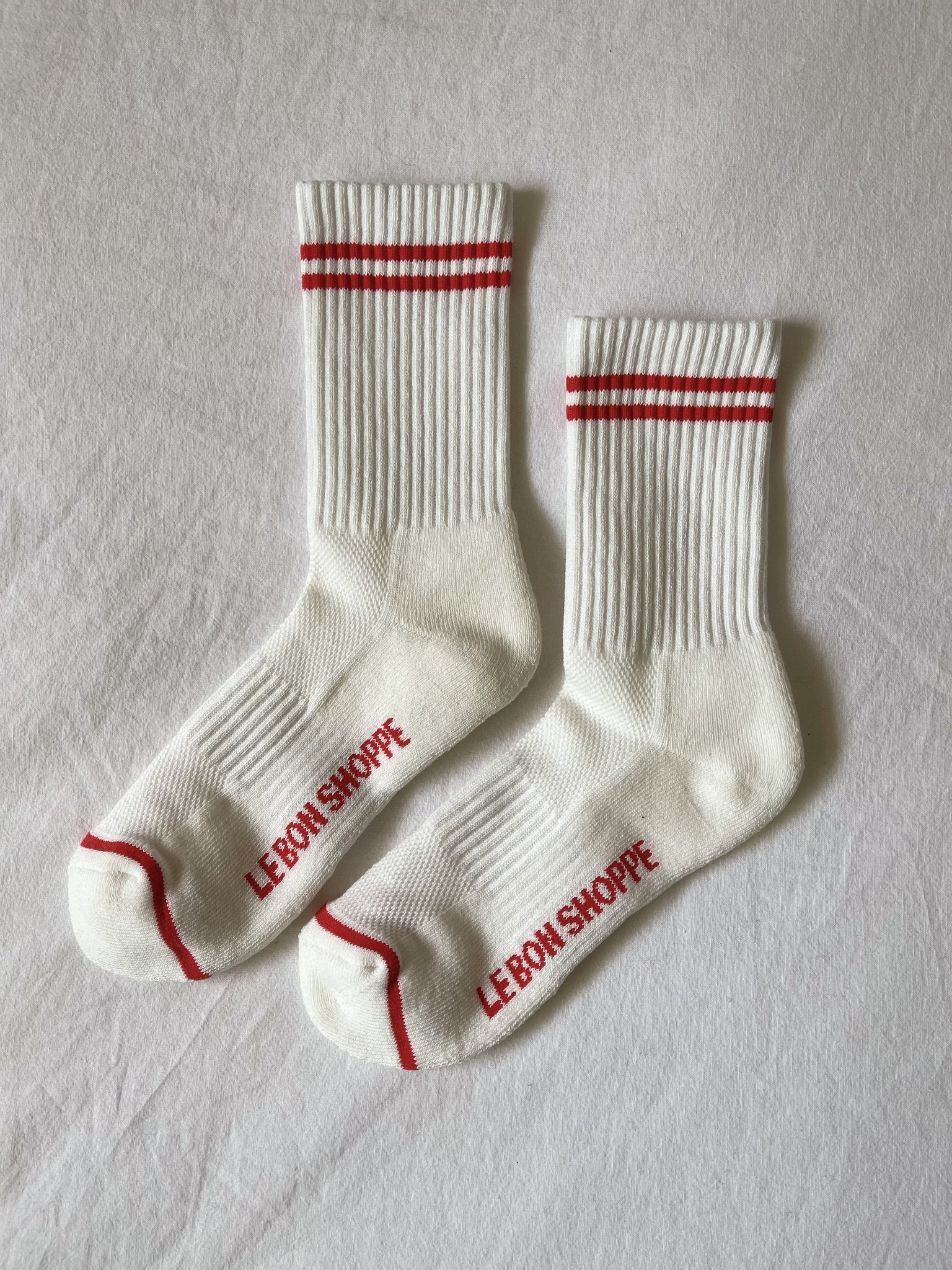 White socks with red stripes laying on white background