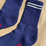Navy socks with white stripes on a kraft paper background.