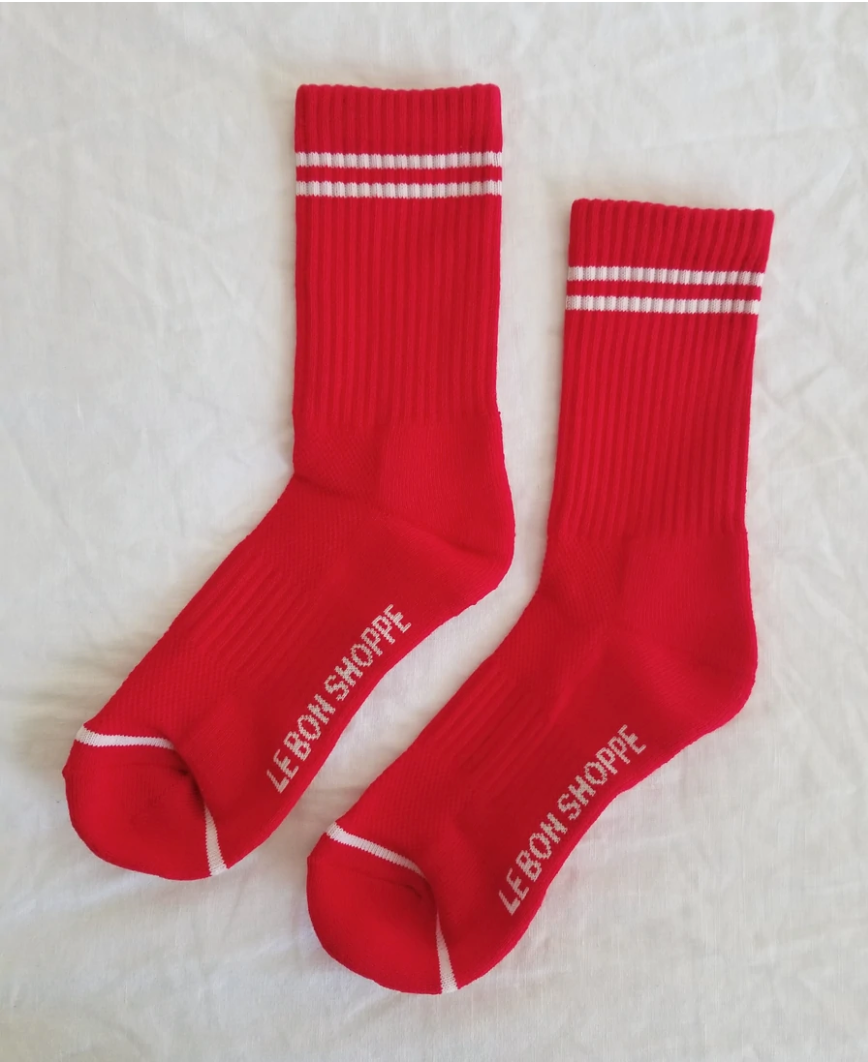 Red socks with white stripes on a light grey background.