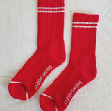 Red socks with white stripes on a light grey background.