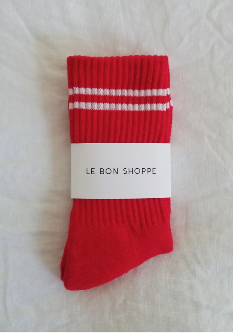 Red socks with white stripes in Le Bon Shoppe packaging.