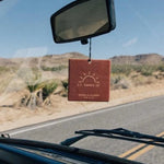 Square Car Freshener hanging from a rearview mirror in a car