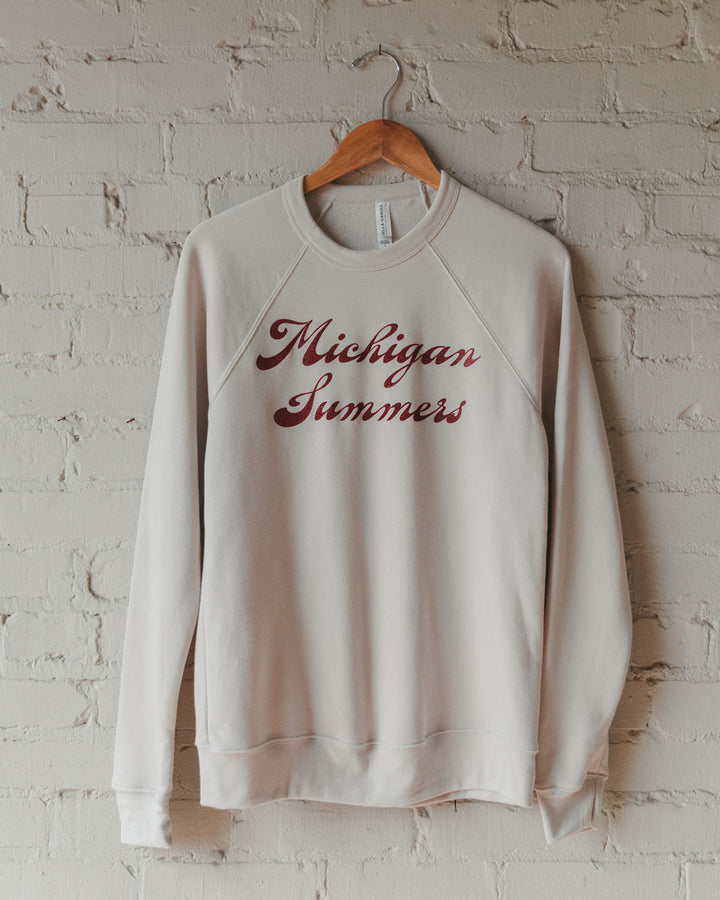 A cream crewneck sweatshirt with Michigan Summers screen-printed on it.