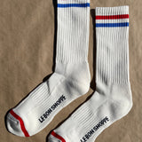 White socks with blue and red socks and e Bon Shoppe branding laying on kraft paper