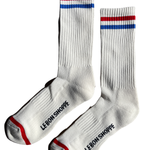 White socks with red and blue stripe and Le Bon Shoppe branding on white background