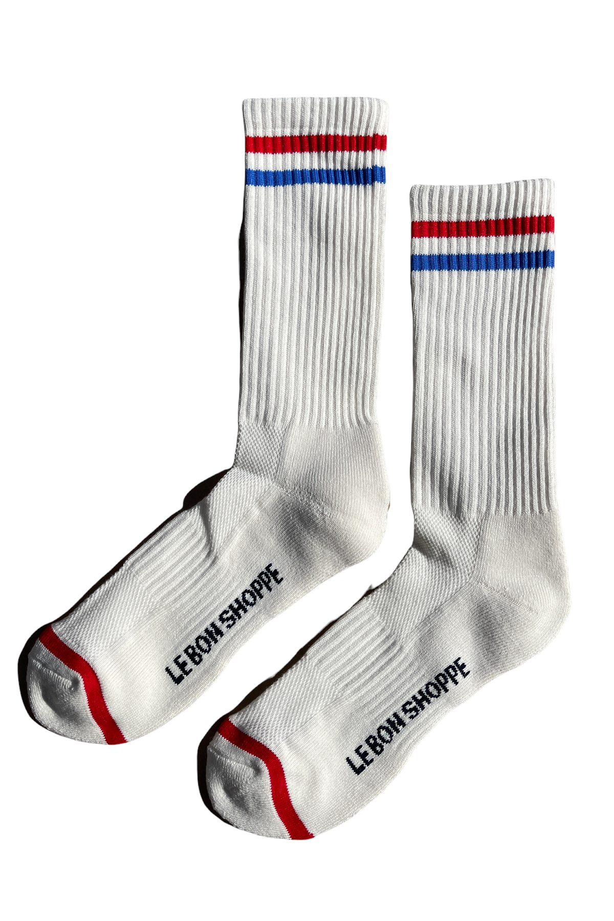 White socks with red and blue stripe and Le Bon Shoppe branding on white background