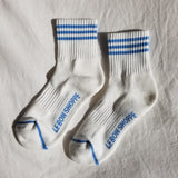 White socks with blue stripes and Le Bon Shoppe branding on white background