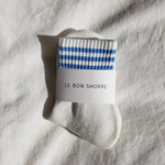 White socks with blue stripes in white Le Bon Shoppe packaging on white background