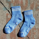 Blue socks with white stripes on a concrete background