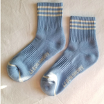 Blue socks with white stripes on a light grey background