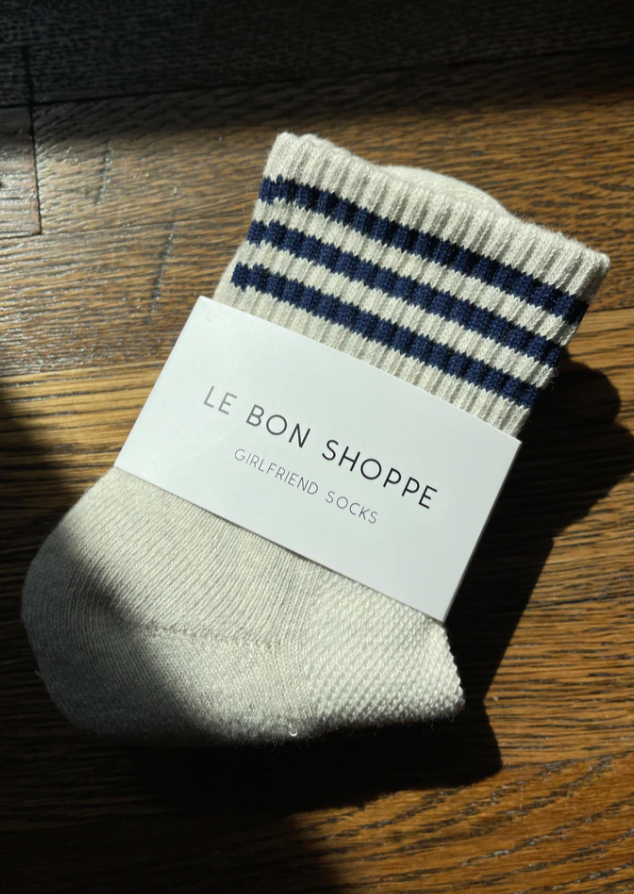 Oatmeal socks with navy stripes on wood background